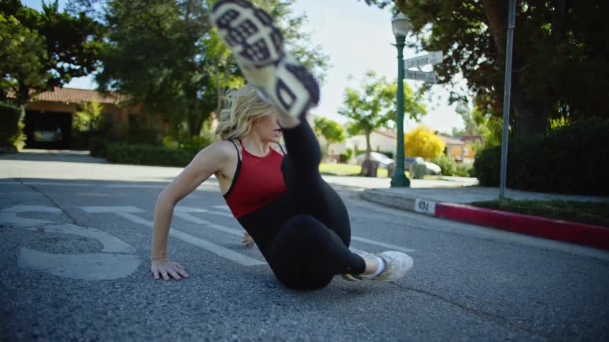 Woman sitting on the floor in a neighborhood lifting stylishly