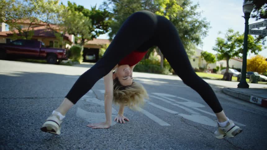 A young woman stretches on a neighborhood street