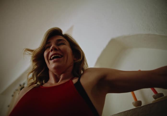 A woman tosses toys around with a boy