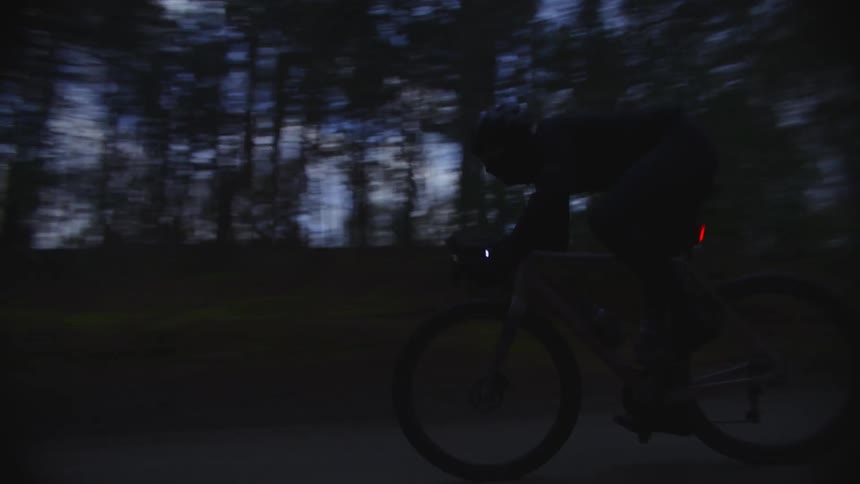 Cyclist passes intersection while cycling through woods