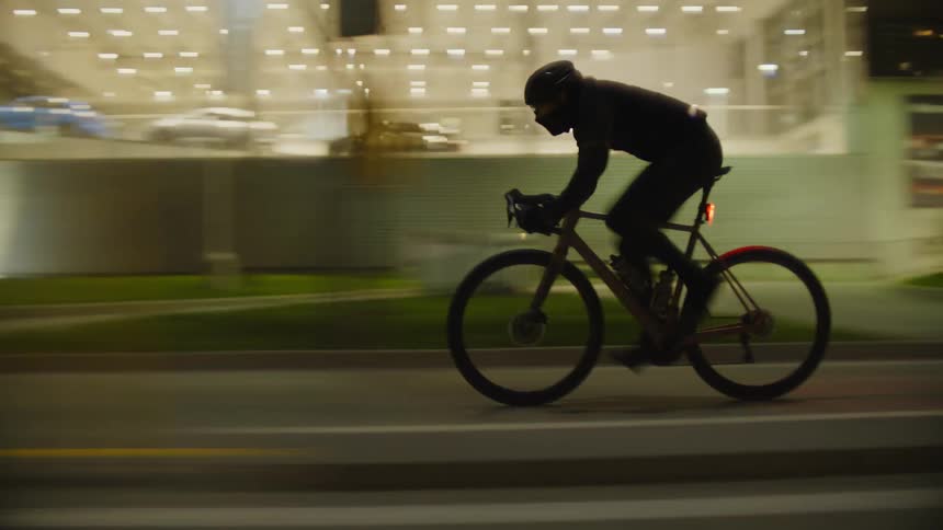 A bicyclist rides through the city at night