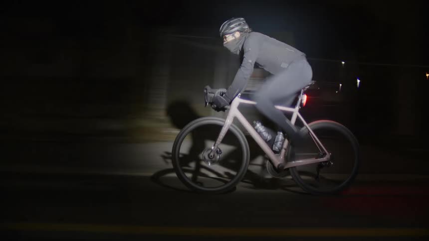 A clip of a cyclist cycling fast in the night