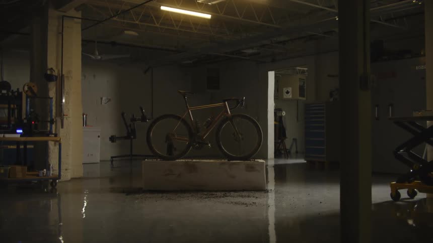 Metallic bicycle on top of a platform inside a room with low lighting