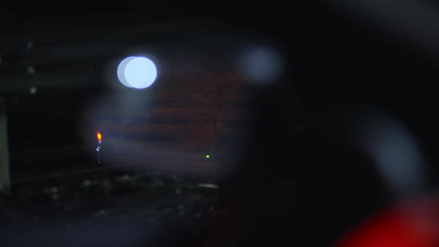 A vehicle drives on a road at night
