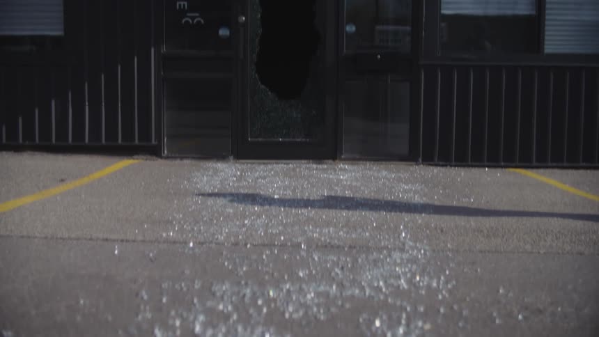 Fragments of glass fallen to the ground overlooking a facade and a broken door