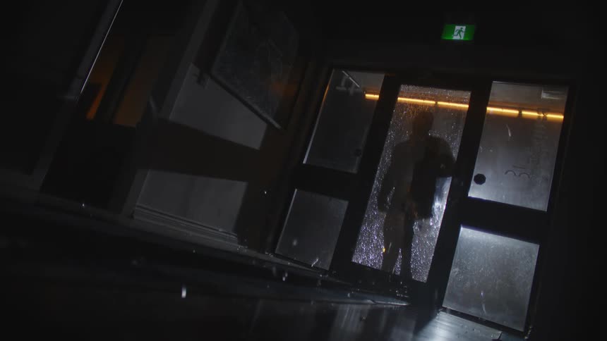 Burglar breaks a store glass door with a brick to break in
