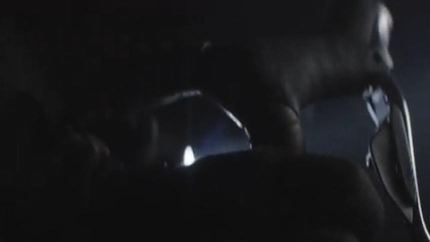 Hooded man riding a bicycle at night