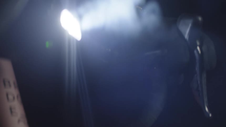 Closeup of a bicycle handlebar with a person pedaling at night