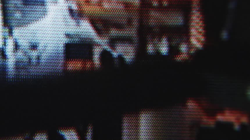A pixelated image of a burglar with a flashlight viewed through a screen