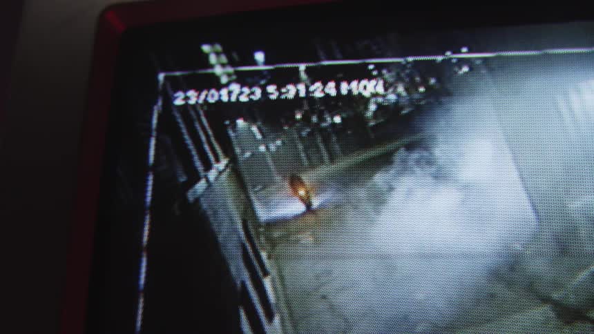 Closeup on a screen playing a video from a camera of a man running at high speed with a bicycle