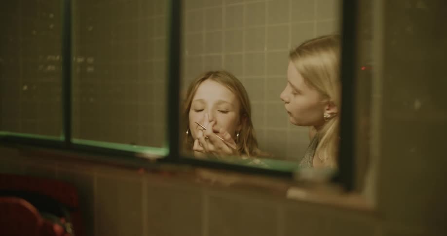 Two girls put on makeup in the bathroom
