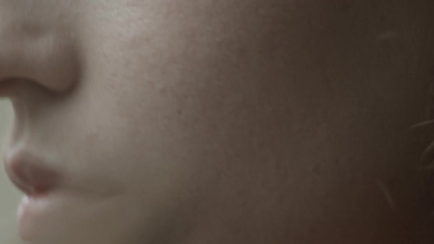 A woman applies makeup to her cheeks using a brush