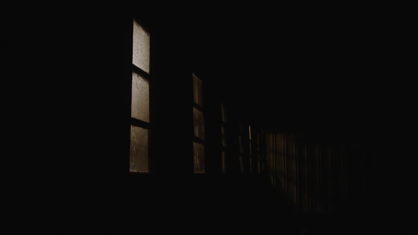 Light shining through translucent glass dimly brightens area near windows in dark room
