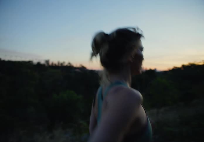 Side portrait of a woman running in nature on a morning
