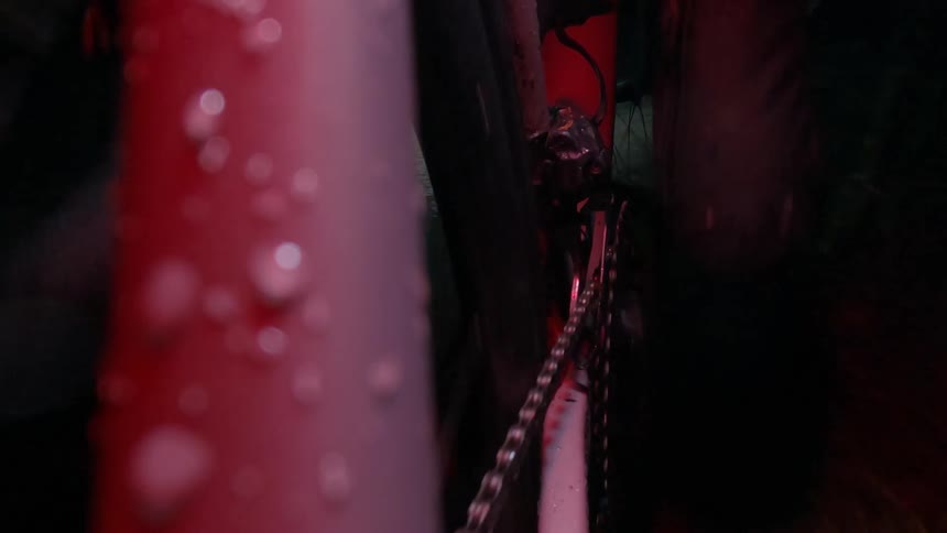 A person rides a wet bike at night