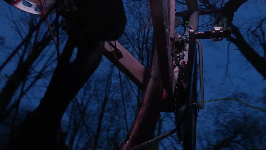 View of a bicycle wheel with a person pedaling at night
