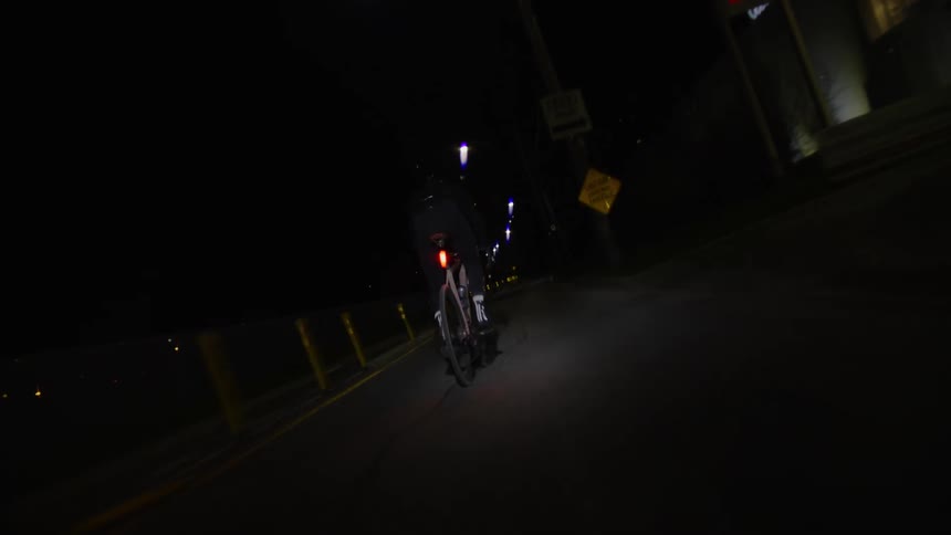 Person cycling on a street at night at high speed