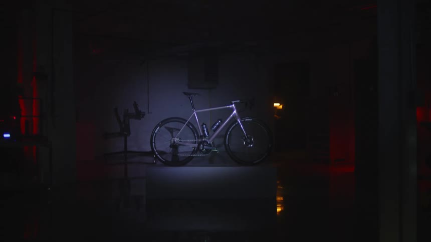 Flashlight illuminating a dark room with a chrome bicycle in the center
