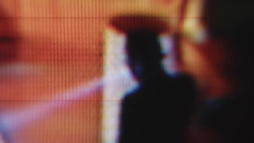 A man walks through a building with a flashlight