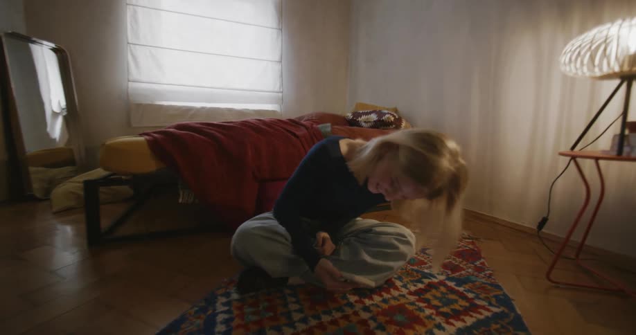 Woman sitting on the carpet smiling and using a cellphone
