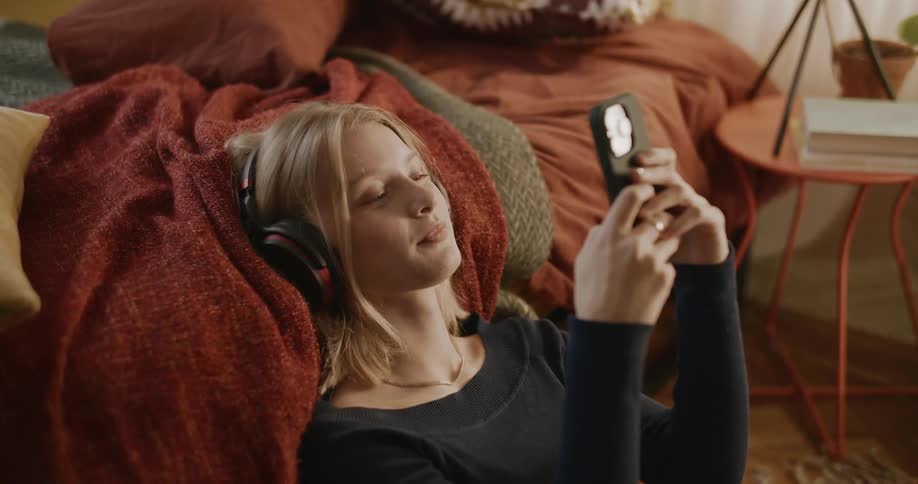 A woman listens to music on her cell phone