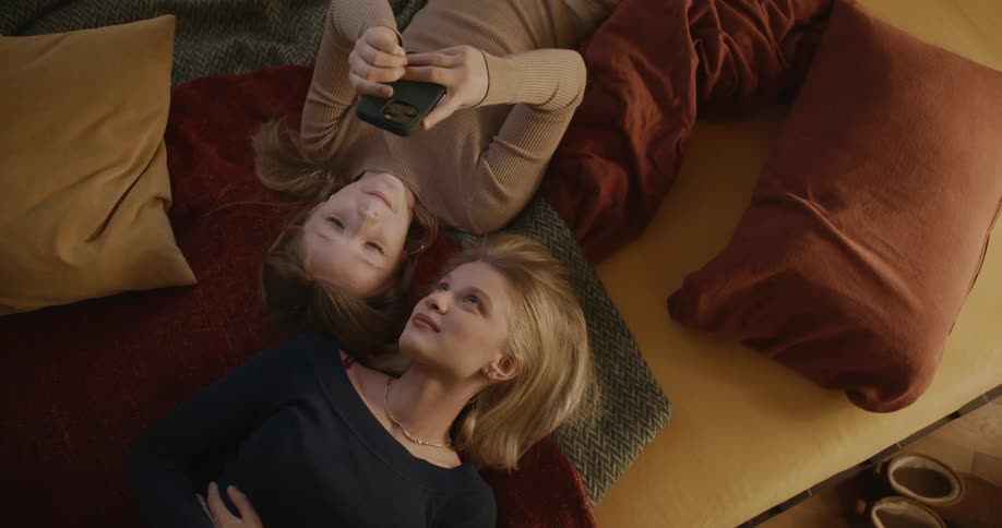 Two teenagers look at a phone together