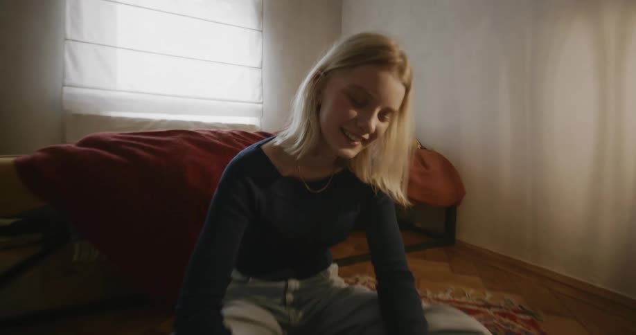 Portrait of a young woman sitting on the floor using her cell phone