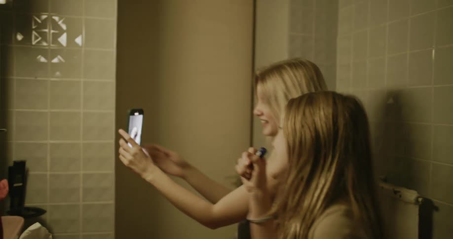 Two girls singing and dancing in the bathroom