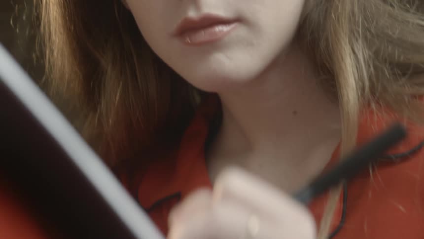 A woman is writing in a notebook