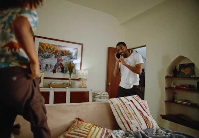 Father talking on the phone interrupts the call and starts playing with his children
