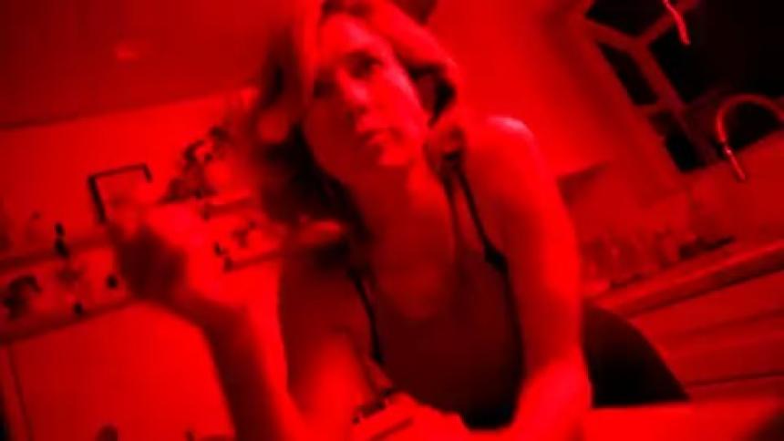 Portrait of a blonde woman eating cereal and dark and red lights flashing