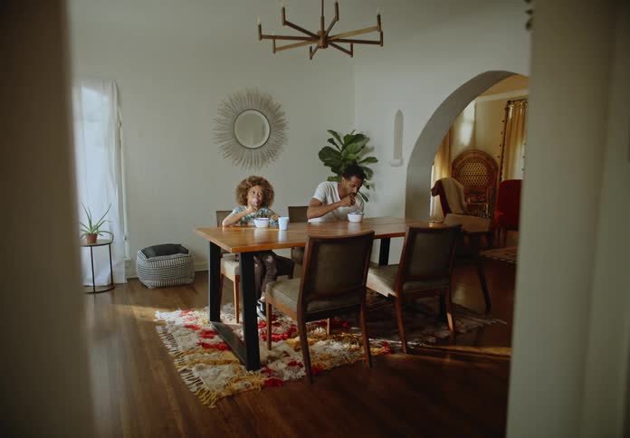 Father and son have breakfast in the dining room during the day