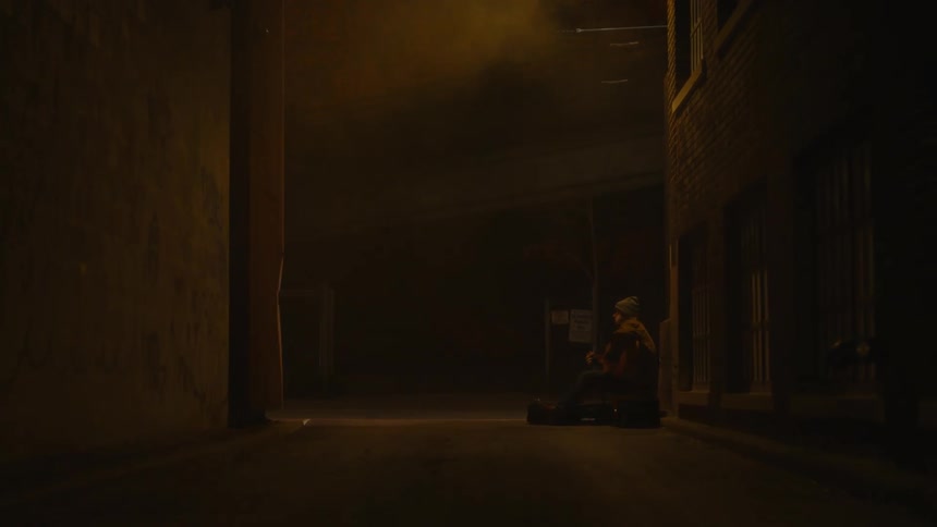 A man watches a bicycle pass by from the alley