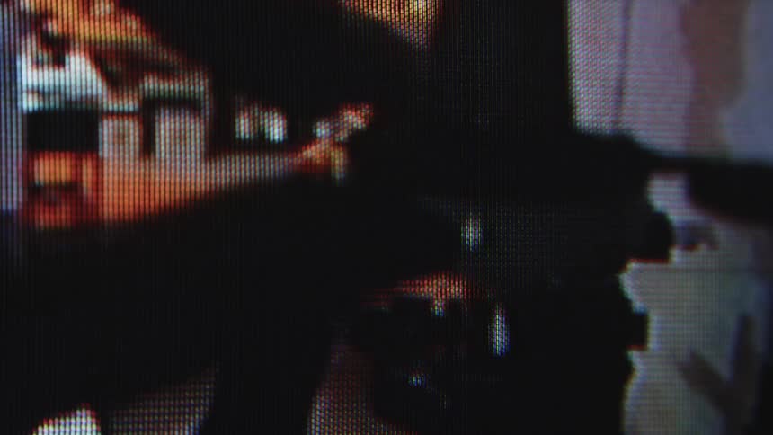 A burglar is searching through the room with a flashlight