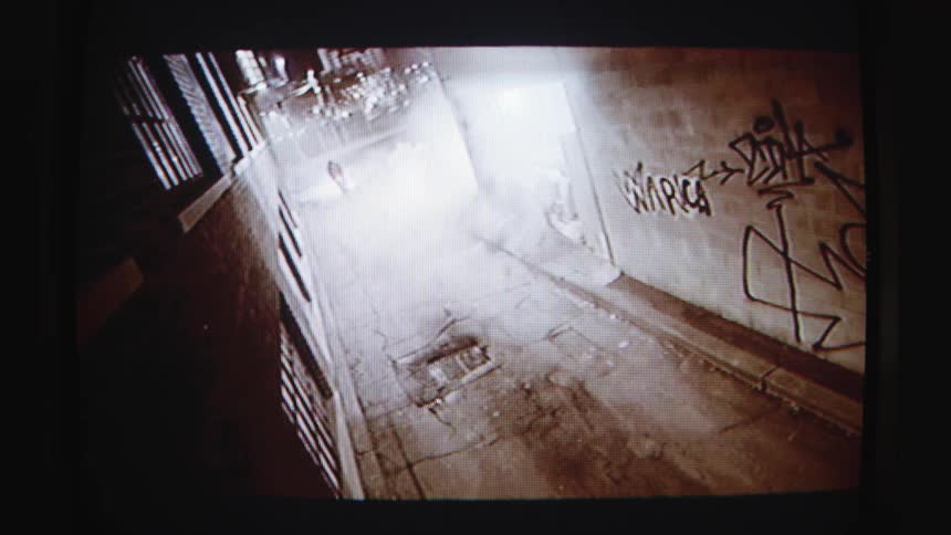 A person on a bicycle at high speed in a city alley