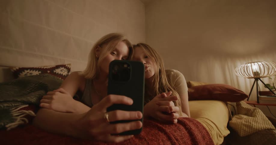 Smiling girls taking a selfie with their cell phone