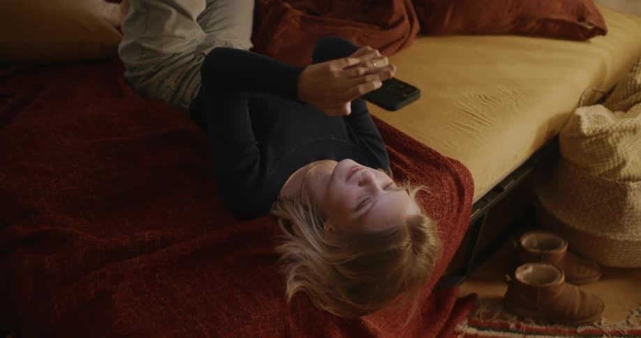 A girl laughs after looking at her cell phone