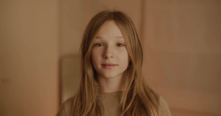 Teenage girl with long hair turns to look at the camera