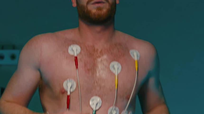 A person is undergoing a medical endurance test with electrodes attached to their chest