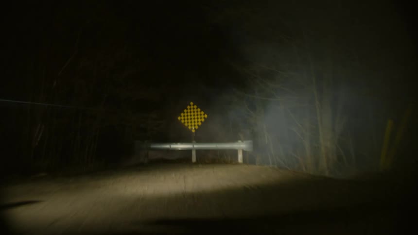 A person riding a bicycle off road through the fog in the forest
