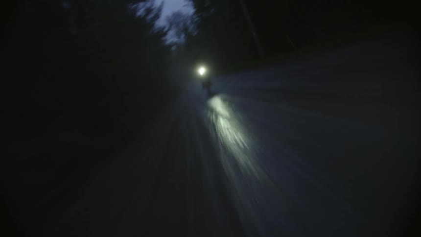 A man rides his bicycle on the wet road