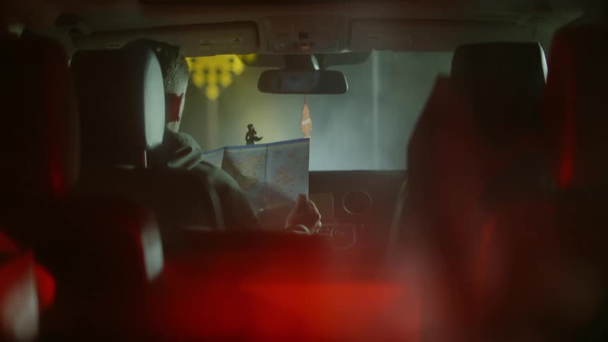 Man reads a map while driving on a foggy and unclear road