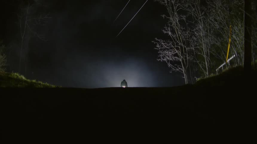 Cyclist speeding on a dirt road at night