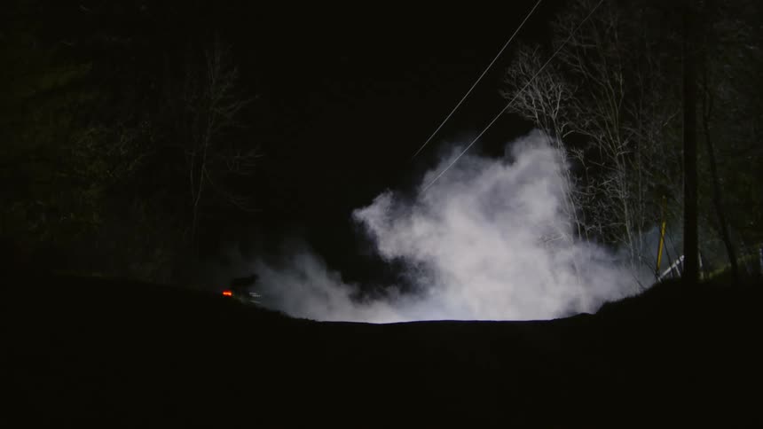Silhouette of a person cycling through a hill at night