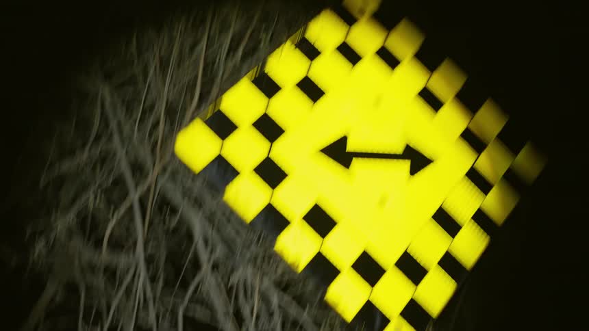 A road sign in a field at night