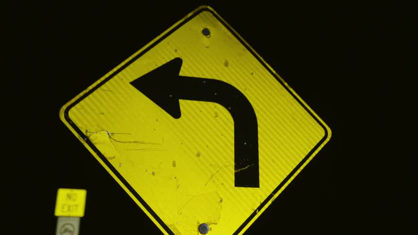 Two yellow traffic signs with a speed limit and turning information