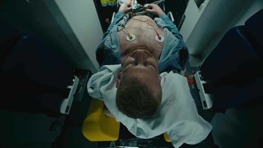 Man on a stretcher being taken out of an ambulance