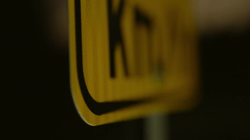 Close up of a reflective street sigh under flashing lights