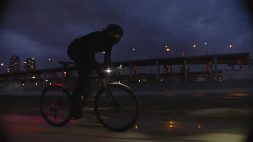 Person riding a bicycle on the highway at night