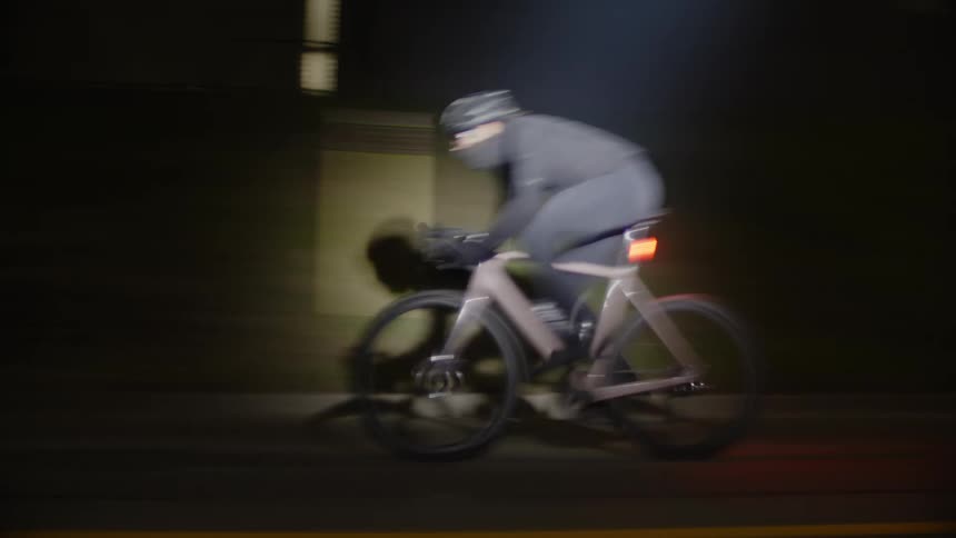A man races his bicycle at night